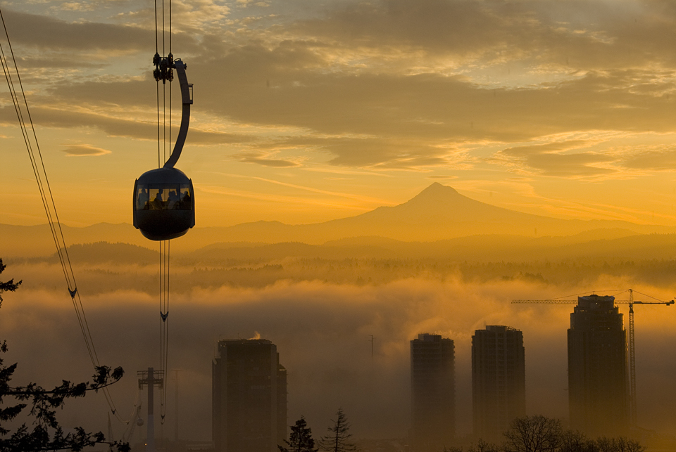 Aerial Tram with fog over the Willamette River with Mt. Hood at sunrise.